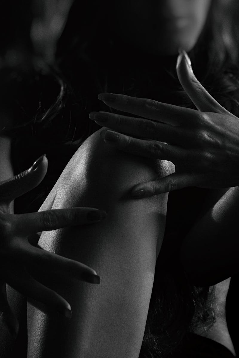 Dramatic black and white silhouette of a woman's hands and body in studio lighting.